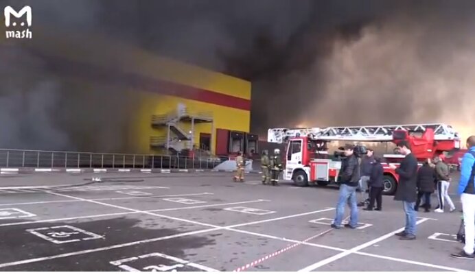"Она вся охвачена огнем". Несколько машин взорвались на подземной парковке горящего ТЦ "Синдика" - кадры